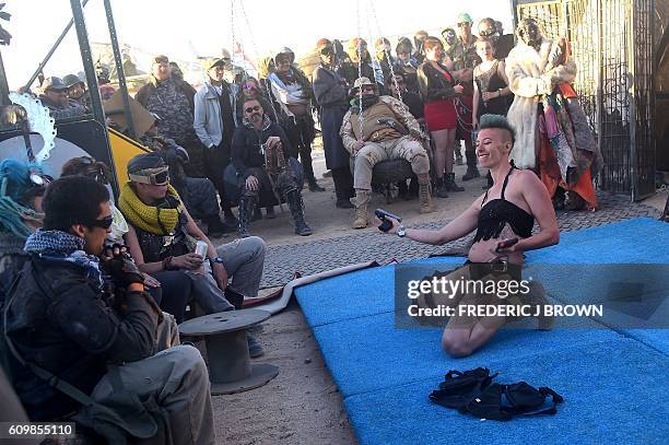 Festival goers enjoy a burlesque performance as people attend the first day of Wasteland Weekend in the high desert community of California City in...