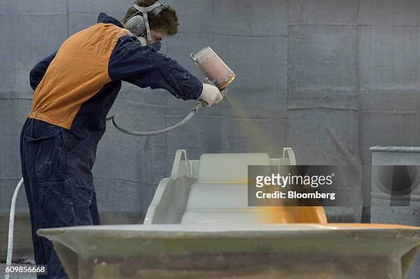 Worker spray paints a fiberglass playground slide at a King's Fiberglass Pty. Ltd. Facility in Melbourne, Australia, on Wednesday, Aug. 17, 2016....