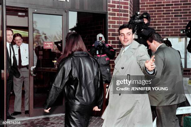 John Wayne Bobbitt points toward photographers as he arrives at the Prince William County Courthouse in Manassas on January 18, 1994 for the fifth...