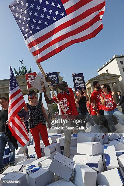 Activists wave American flags as the celebrate after bashing down what they called a cardboard "Wall of Hate" showing Republican U.S. Elections...