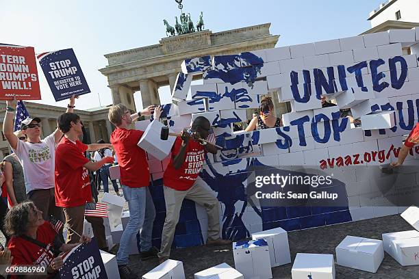 Activists bash down what they called a cardboard "Wall of Hate" showing Republican U.S. Elections candidate Donald Trump in front of the Brandenburg...