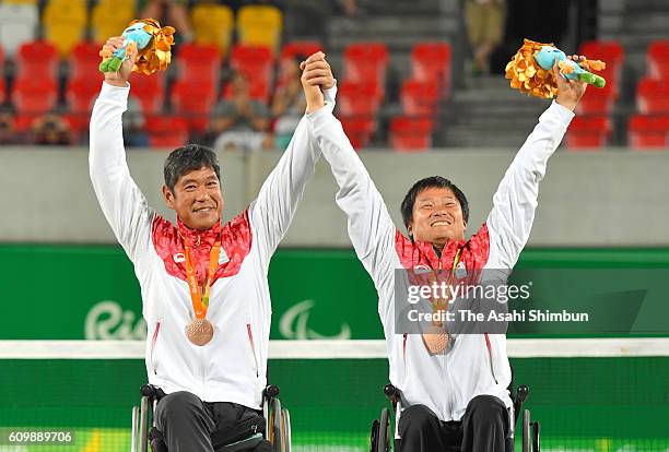 Bronze medalists Shingo Kunieda and Satoshi Saida of Japan celebrate on the podium at the medal ceremony for the Wheelchair Tennis Men's Doubles on...