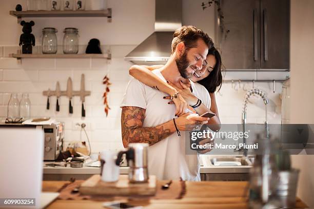 young couple at home using smartphone - morning breakfast time - no ordinary love stockfoto's en -beelden