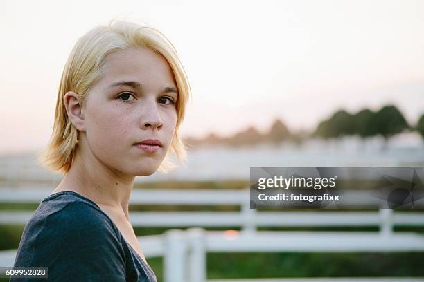 portrait: cute blonde teenager girl looks seriously at the camera - cute 15 year old girls stock pictures, royalty-free photos & images