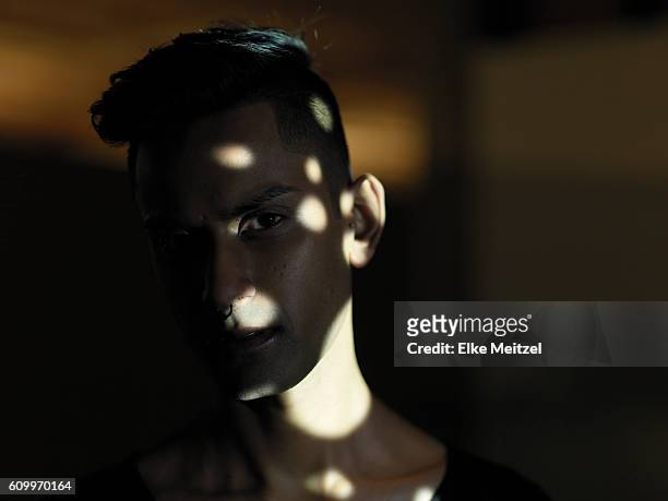 portrait of young man with abstract light patterns on his face - invisible man stock-fotos und bilder