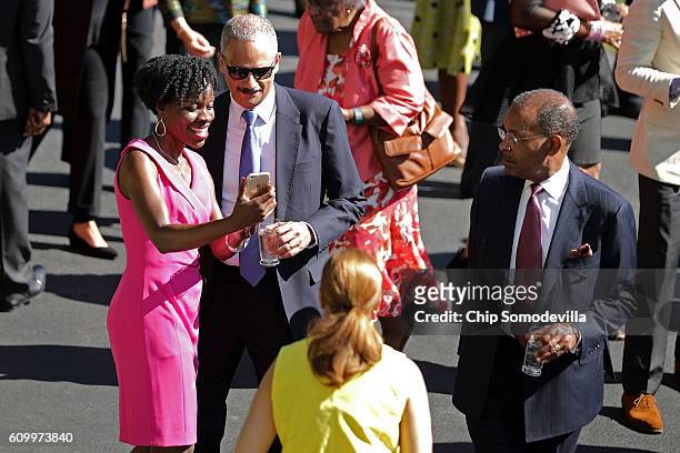 Former Attorney General Eric Holder poses for a selfie during a reception in honor of the opening of the Smithsonian National Museum of African...