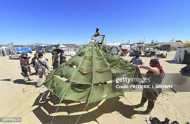 People put up their tent as festival goers attend day two of Wasteland Weekend in the high desert community of California City in the Mojave Desert,...