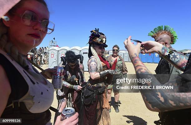 Woman receives help with her costume as festival goers attend day two of Wasteland Weekend in the high desert community of California City in the...