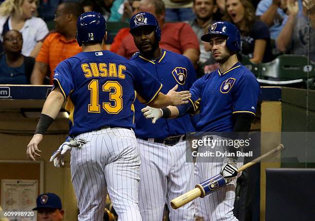 Andrew Susac of the Milwaukee Brewers is congratulated by teammates Ryan Braun and Chris Carter after scoring a run in the seventh inning against the...