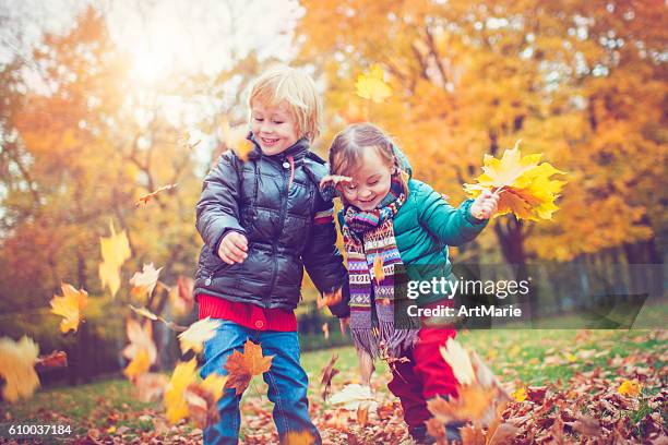 little boy and girl in autumn park - young leafs stock pictures, royalty-free photos & images