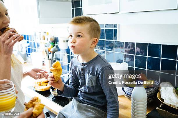 glückliche familie hat frühstück in der küche - pain au chocolat stock-fotos und bilder