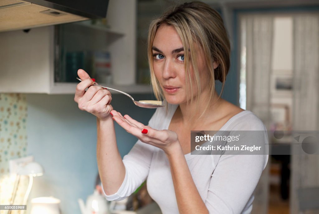 Young woman cooking, testing pasta