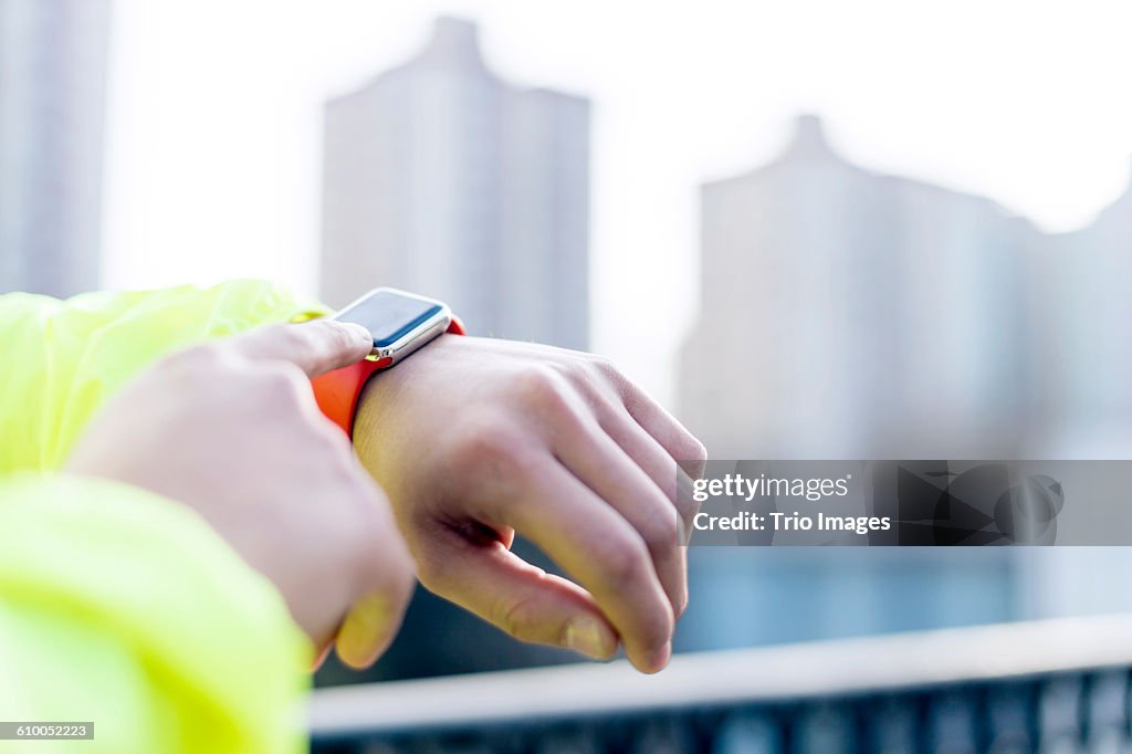 Man using smart watch outdoors after jogging