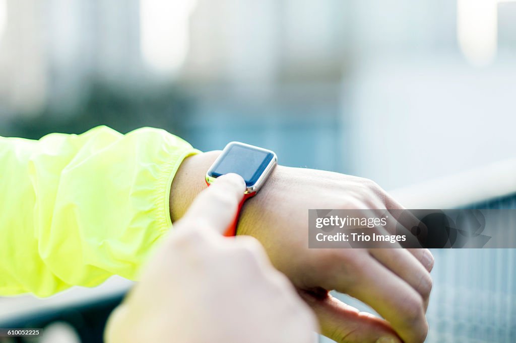 Man using smart watch outdoors after jogging