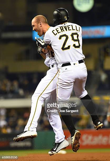 Jacob Stallings of the Pittsburgh Pirates celebrates his game winning RBI single with Francisco Cervelli during the eleventh inning against the...
