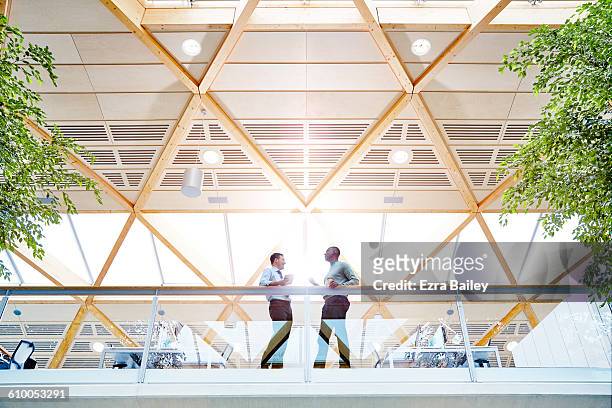 work colleagues having a catch up in modern office - place of work imagens e fotografias de stock