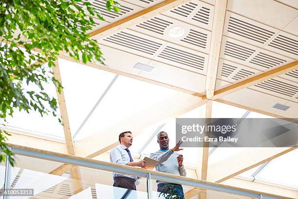 businessmen chatting in sustainable office. - two people stock pictures, royalty-free photos & images