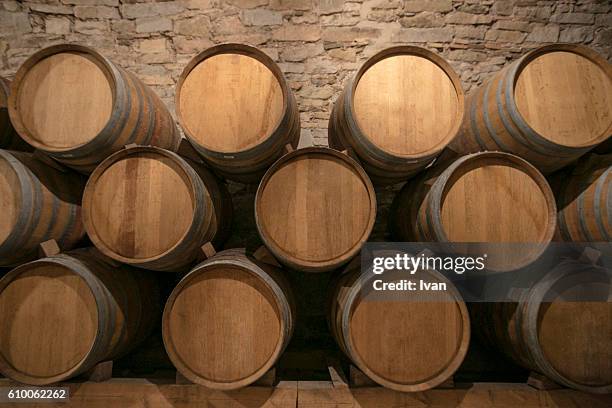 stacked oak barrels in a winery - baril photos et images de collection