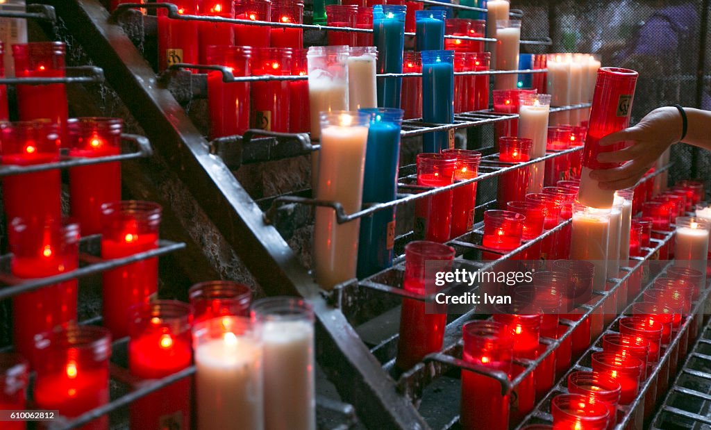 A collection of lit prayer candles in a church