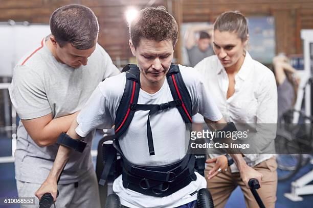 Physical therapists guiding man walking