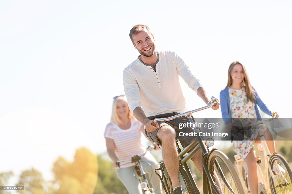 Smiling young man bike riding with women