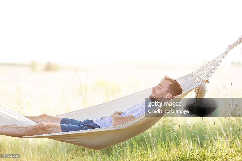 Young man sleeping in summer hammock