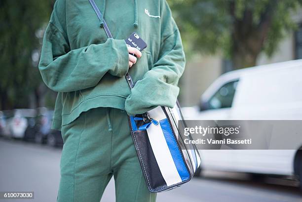 Guest poses wearing Vetements sweatshirt and pants, Nike Cortez shoes and Balenciaga bag after the Prada show during Milan Fashion Week Spring/Summer...