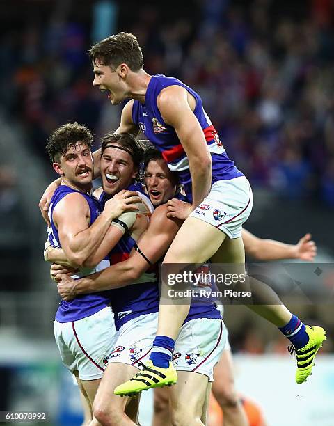 Tom Liberatore, Marcus Bontempelli, Dale Morris and Josh Dunkley of the Bulldogs celebrate victory after the AFL First Preliminary Final match...