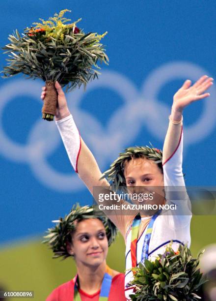 French gold medallist Emilie Le Pennec and US silver medallist Terin Humphrey celebrate on the podium after winning the gold medal in the women's...