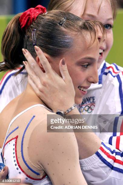 French Emilie Le Pennec is congratulated by her teammate Marine Debauve after winning the gold medal in the women's uneven bars final on August 22,...