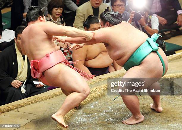 Sato pushes Ura out of the ring to win during day twelve of the Grand Sumo Autumn Tournament at Ryogoku Kokugikan on September 22, 2016 in Tokyo,...