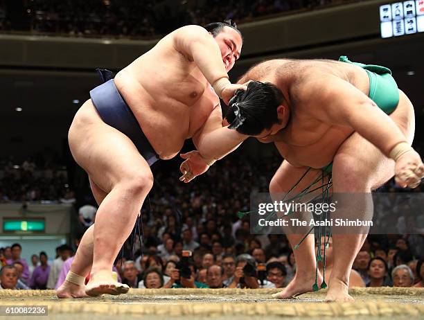 Ozeki Kisenosato throws Brazilian Kaisei to win during day twelve of the Grand Sumo Autumn Tournament at Ryogoku Kokugikan on September 22, 2016 in...