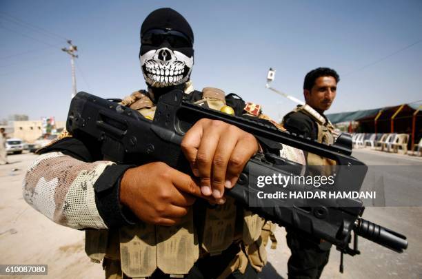 Members of the Popular Mobilisation Units supporting the government forces stand on the outskirts of the holy Iraqi city of Najaf on September 24 as...