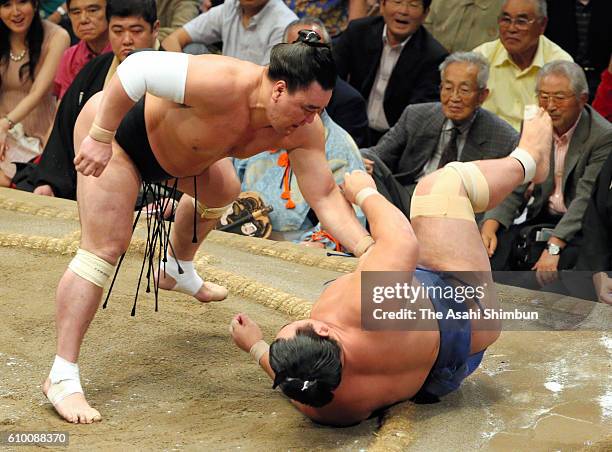 Mongolian yokozuna Harumafuji throws ozeki Kotoshogiku to win during day twelve of the Grand Sumo Autumn Tournament at Ryogoku Kokugikan on September...