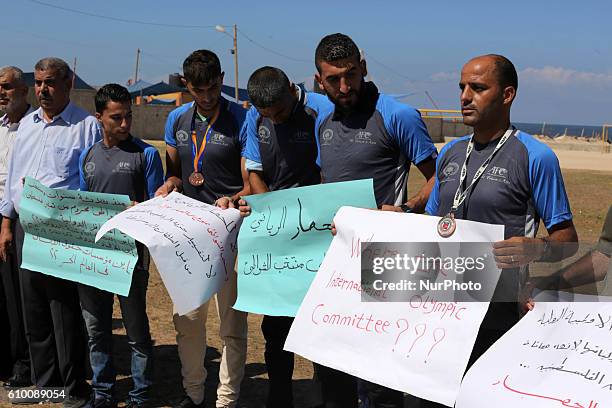 Palestinian sportsmen hold banners during a protest against the Israeli authorities to prevent their travel to Vietnam through the Erez crossing, in...