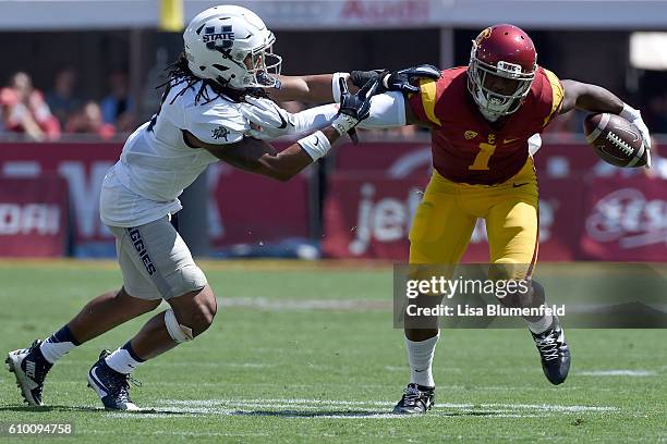 Darreus Rogers of the USC Trojans advances the ball in the 2nd quarter against Wesley Bailey of the Utah State Aggies at Los Angeles Coliseum on...