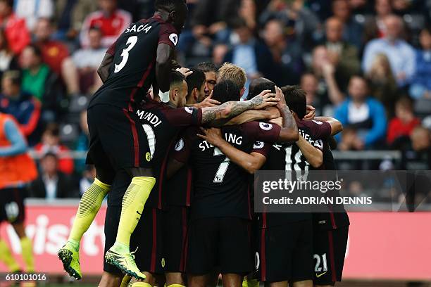 Manchester City players crowd around Manchester City's Argentinian striker Sergio Aguero after he scored their second goal from the penalty spot...