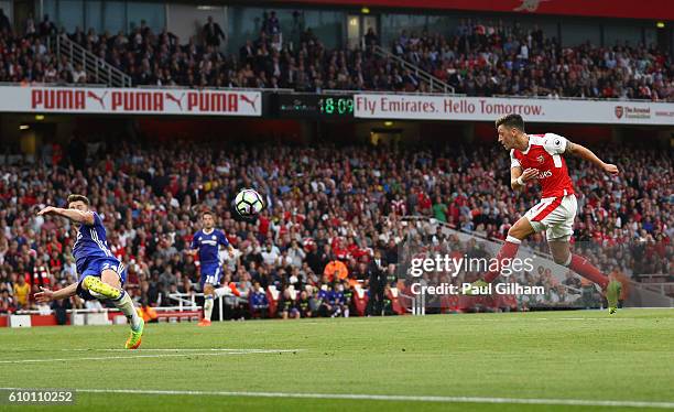 Mesut Ozil of Arsenal scores his sides third goal during the Premier League match between Arsenal and Chelsea at the Emirates Stadium on September...