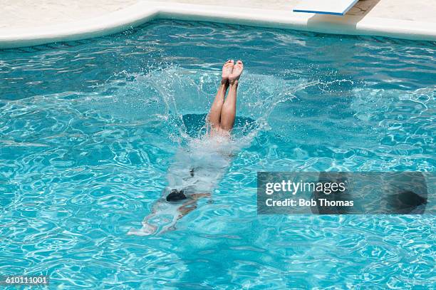 young woman diving into a swimming pool - lanzarse al agua salpicar fotografías e imágenes de stock