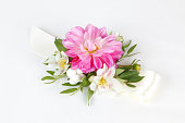 Pink, white and green wrist corsage isolated on white background