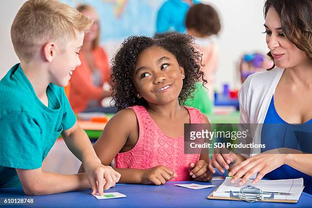 sassy little girl looking at male classmate during lesson - flash card stock pictures, royalty-free photos & images
