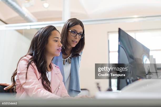 business woman working together and sharing a computer. - casual clothing stock pictures, royalty-free photos & images