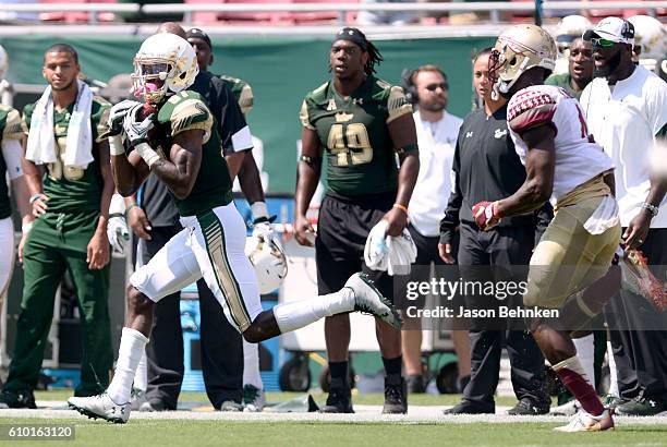 Wide receiver Rodney Adams of the South Florida Bulls makes the catch over defensive back Tarvarus McFadden of the Florida State Seminoles on his way...