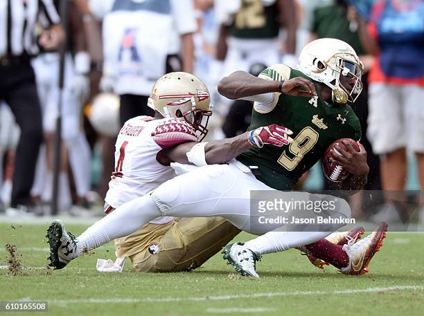 Quarterback Quinton Flowers of the South Florida Bulls is sacked by defensive back Tarvarus McFadden of the Florida State Seminoles during the 1st...