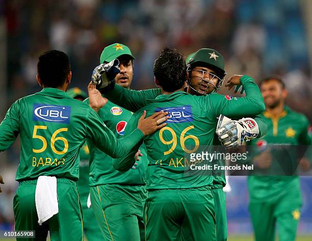 Umar Akmal and Shoaib Ahmed of Pakistan celebrates the wicket of Johnson Charles of the West Indies during the second T20 International match between...