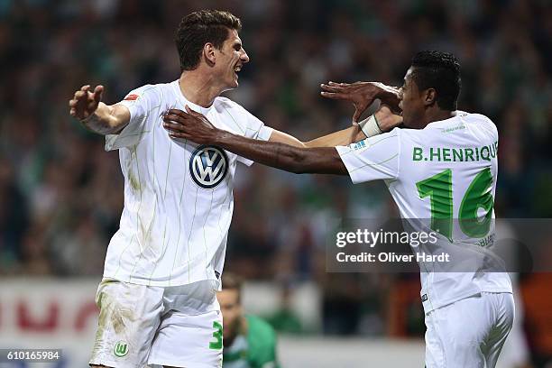 Bruno Henrique of Wolfsburg celebrates with Mario Gomez after his first goal during the Bundesliga match between Werder Bremen and VfL Wolfsburg at...