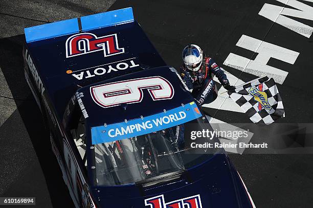 William Byron, driver of the Liberty University Toyota, celebrates with the checkered flag after winning the NASCAR Camping World Truck Series UNOH...