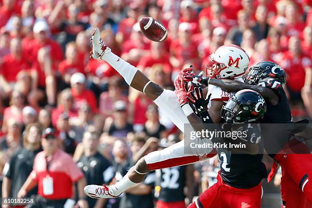 Tyrell Gilbert of the Cincinnati Bearcats and Alex Thomas of the Cincinnati Bearcats break up a pass intended for James Gardner of the Miami Ohio...