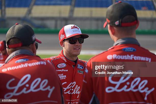 Ryan Reed, driver of the Lilly Diabetes / American Diabetes Association Ford Mustang Ford, talks with crewmen next to his car before qualifying for...