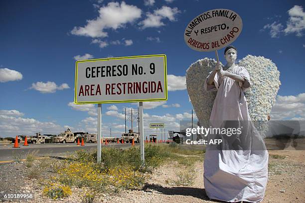 Young man who is a member of the "Psalm 100" evangelical church, dressed as an angel messenger of peace, carries a sign stating "food, family and...